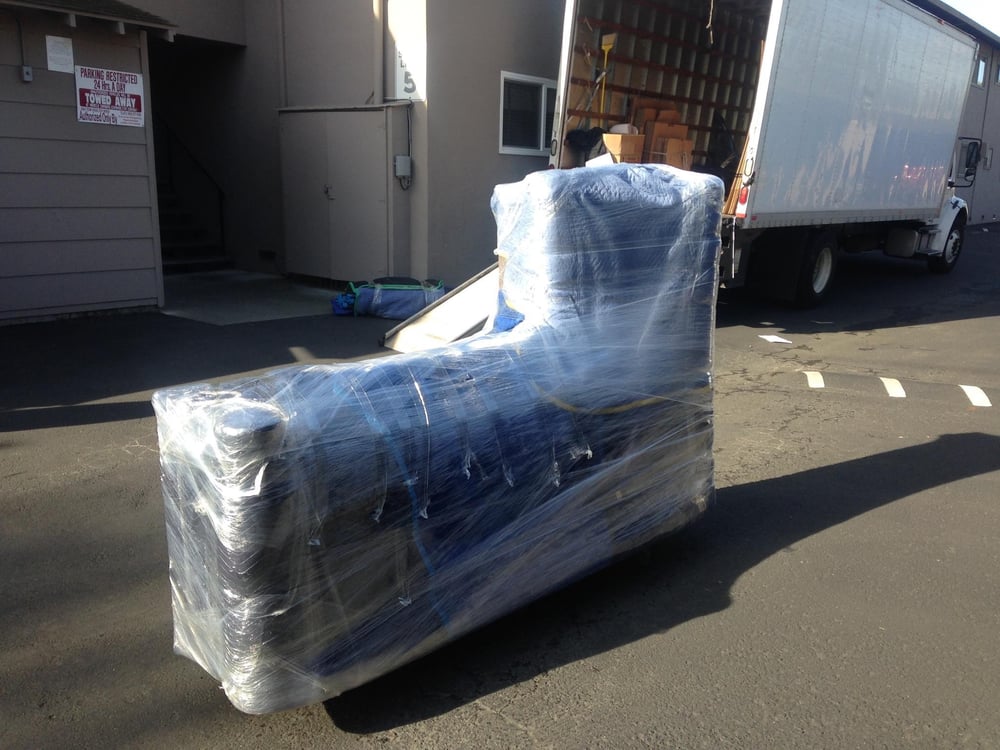 Furniture wrapped and protected beside a Spartan moving truck.