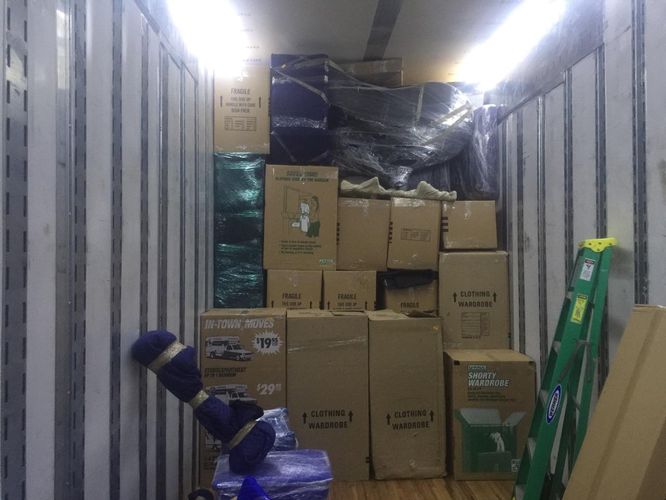 Packed moving truck with secured boxes and furniture.